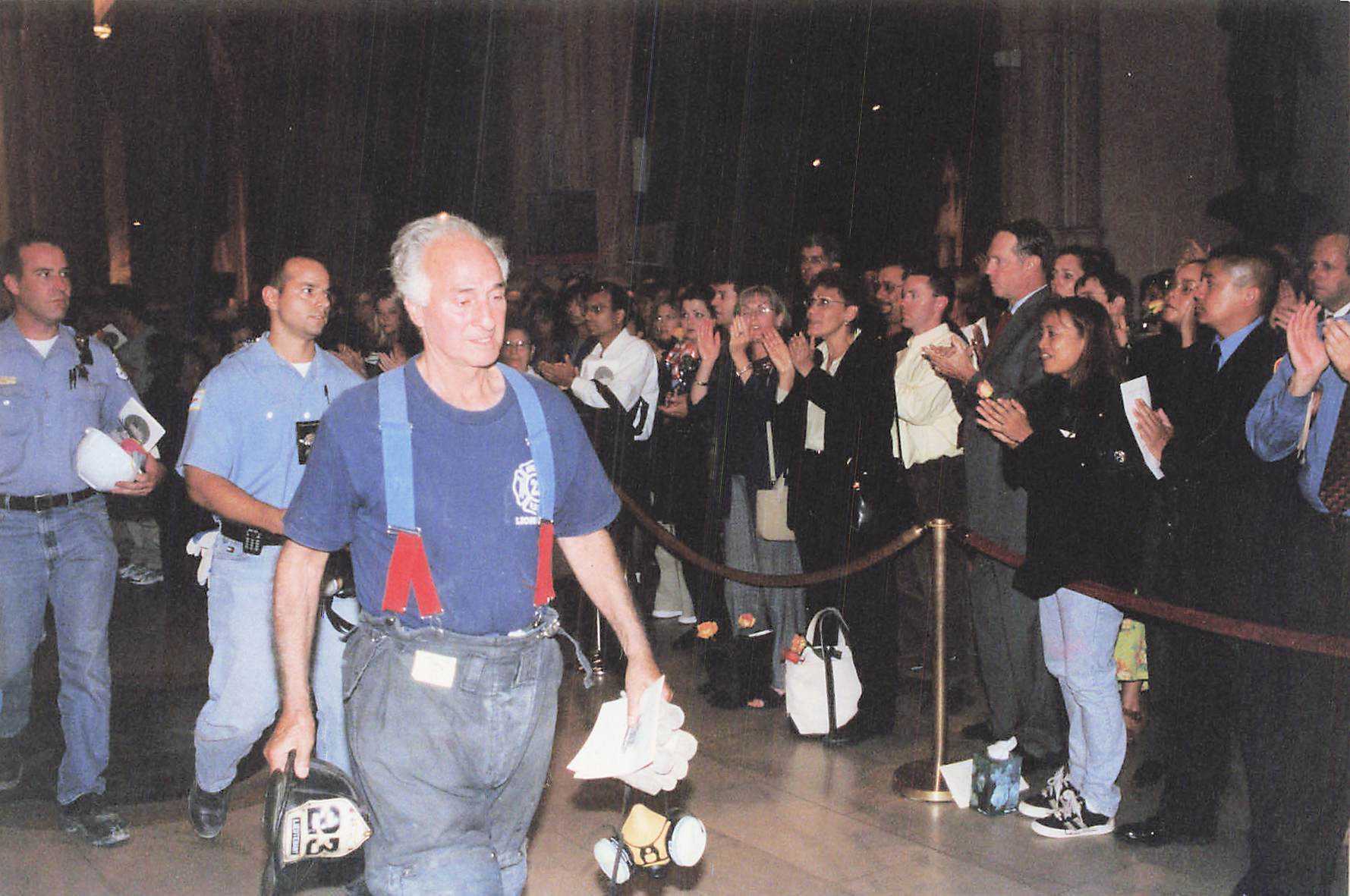 A firefighter is welcomed with applause following the procession.