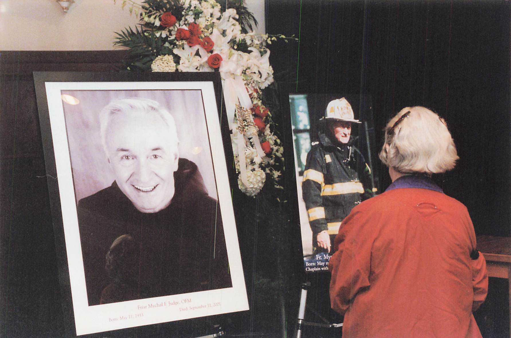Mourners view a memorial photo of Father Mychal Judge, OFM